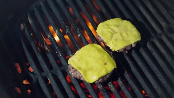 Cucina. cucinare hamburger. Primo piano. grigliate di polpette di hamburger di carne fresca con formaggio fuso giallo sul braciere. processo di arrostimento di medaglioni di carne di manzo sulla griglia a fiamma calda. fast food, spazzatura — Video Stock