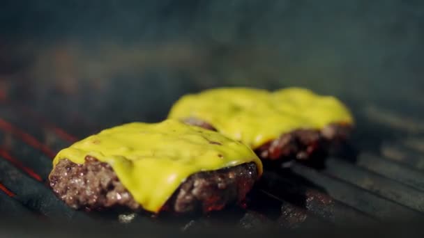 Cucina. cucinare hamburger. Primo piano. grigliate di polpette di hamburger di carne fresca con formaggio fuso giallo sul braciere. processo di arrostimento di medaglioni di carne di manzo sulla griglia a fiamma calda. fast food, spazzatura — Video Stock