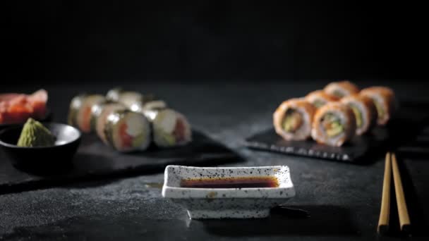 Tradycyjne japońskie jedzenie. zbliżenie. Super filmik ze świeżym sushi wpadającym w sos sojowy. Sushi Rolls w barze sushi lub restauracji. — Wideo stockowe
