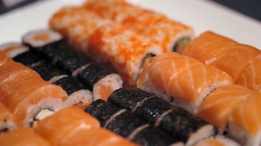 Geleneksel Japon yemekleri. Yakın plan. Yeni pişmiş, çeşitli suşi dürümleri bir teslimat kutusunda suşi büfesi..
