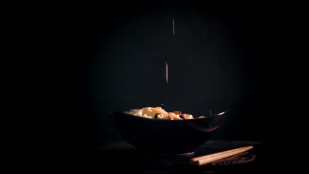 Tradiční japonské jídlo. detailní záběr. Šéfkuchař sype horké nudle z mořských plodů parmezánem. zpomalit. umění sloužící v restauraci — Stock video