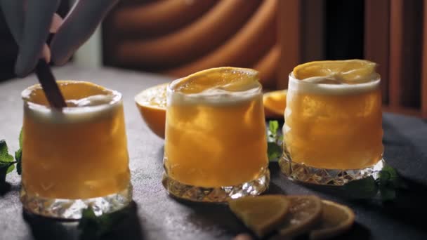 Bartender makes cocktails. close-up. the bartender decorates cocktails with cinnamon sticks. at the bar, restaurant or disco club. — Stock Video