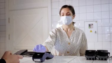 NFC teknolojisi. Garson, koruyucu maske ve eldiven takmış, parmak izleri müşterilerin ulaşamayacağı kadar çok. Elektronik ödeme makinesinden ya da kart okuyucudan telefonla ödeme yapmak. Cep telefonu, kablosuz