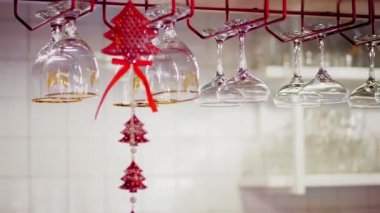 Bardaklar temiz. Yakın plan. İçki ve kokteyller için farklı türde bardaklar barın yukarısındaki özel tutuculara Noel süsü olarak asılır.