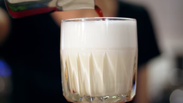 Latte en vidrio. primer plano, barista hace café con leche, suavemente añade café a la leche espumosa, en un hermoso vaso. — Vídeos de Stock