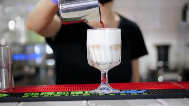 Latte in glas. close-up, barista maakt latte, voegt zachtjes koffie toe aan schuimmelk, in een mooi glas. — Stockvideo