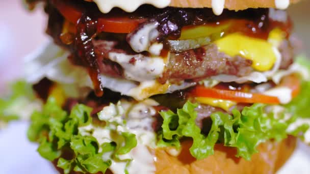 Гамбургер, бургер. крупным планом. сочный, вкусный, свежеприготовленный, жирный бургер с картошкой фри и соусом, на деревянном подносе. фастфуд, фастфуд. — стоковое видео