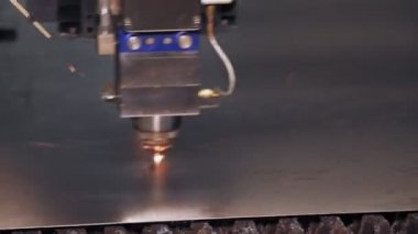 Metal levha için lazer kesme makinesi. Yakın plan. CNC fiber lazerli modern makine metal levha kesiyor. Kesme işlemi sırasında lazer ışınından parlak kıvılcımlar uçuşuyor