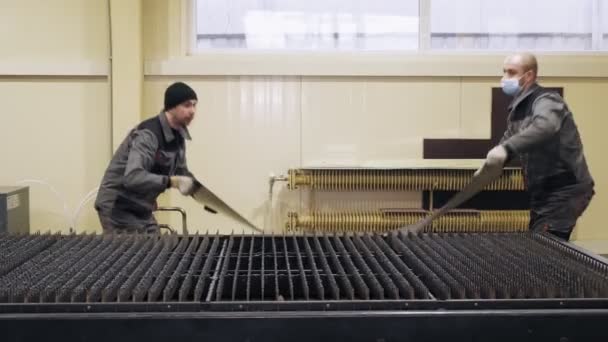 CHERKASSY, UKRAINE, 28 ARALIK 2020: metal levha kesme makinesi. Erkek işçiler lazer kesme makinesi masasında ince bir metal levha kurar.. — Stok video