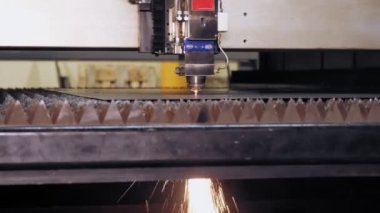 Metal levha için lazer kesme makinesi. Yakın plan. CNC fiber lazerli modern makine metal levha kesiyor. Kesme işlemi sırasında lazer ışınından parlak kıvılcımlar uçuşuyor