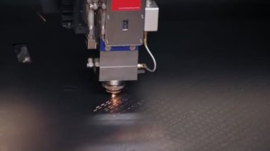Metal levha için lazer kesme makinesi. Yakın plan. CNC fiber lazerli modern makine metal levha kesiyor. Kesme işlemi sırasında lazer ışınından parlak kıvılcımlar uçuşuyor