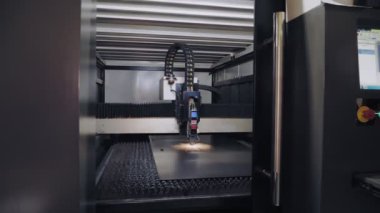 Metal levha için lazer kesme makinesi. CNC fiber lazerli modern makine metal levha kesiyor. Kesme işlemi sırasında lazer ışınından parlak kıvılcımlar uçuşuyor