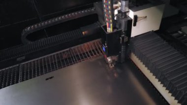 Metal levha için lazer kesme makinesi. Üst Manzara. CNC fiber lazerli modern makine metal levha üzerindeki desenleri kesiyor. Kesme işlemi sırasında lazer ışınından parlak kıvılcımlar uçuşuyor