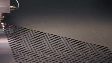 Metal levha için lazer kesme makinesi. Yakın plan. CNC fiber lazerli modern makine metal levha üzerindeki desenleri kesiyor. Kesme işlemi sırasında lazer ışınından parlak kıvılcımlar uçuşuyor