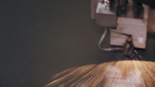 Машина лазерной резки листового металла. крупным планом. вид сверху. современная машина с ЧПУ волоконный лазер резки узоры на листовой металлической пластины. яркие горящие искры летят от лазерного луча во время резки — стоковое видео