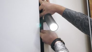 Yol gösteren lamba. Aydınlatma Yakın plan. Adam lamba kuruyor. Aydınlatma armatürlerinin kolay kurulumu. Modern lambalar. Yeni ışıklandırma teknolojisi, enerji tasarrufu.
