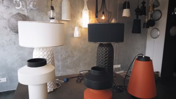 Lampu dan lampu gantung di toko. berbagai macam iluminator untuk desain interior. Setengah dibongkar chandeliers keramik, lampu, berbaring di atas meja. di showroom toko. dekorasi interior ringan. — Stok Video