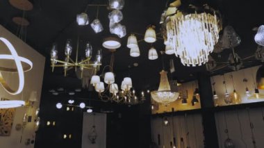 Işıkları kapatıyorum. Dükkanda avizeler. Mağaza vitrininde bir sürü farklı türde lamba ve avize açılıyor. İç tasarım için çeşitli aydınlatma araçları.