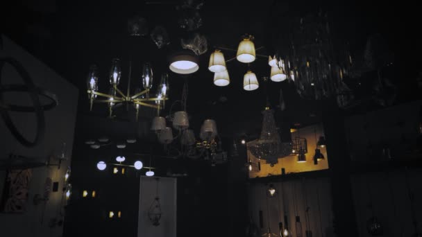 Licht an. Kronleuchter im Geschäft. Viele verschiedene Arten und Formen von Lampen, Kronleuchtern werden im Showroom des Ladens eingeschaltet. Sortiment von Beleuchtungskörpern für den Innenausbau. — Stockvideo