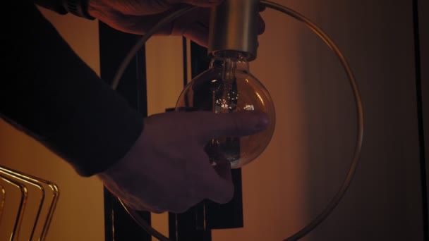 Ik schroef de lamp. gloeilamp. close-up. man vervangen, gloeilamp vervangen door Edison gloeidraad, schroeven het in lamphouder en stak het op. — Stockvideo