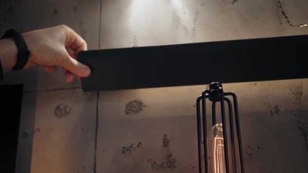 Candelabros en la tienda. Primer plano. un hombre demuestra una lámpara de pared con estilo con una bombilla fluorescente, tubo. gran variedad de iluminadores para el diseño de interiores. — Vídeos de Stock