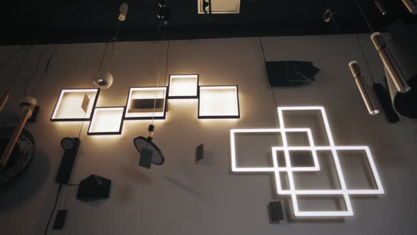 Ligar, desligar as luzes. lustres na loja. Muitas lâmpadas de parede diferentes, lustres estão desligando e ligado no showroom loja. sortimento de iluminadores para design de interiores. — Vídeo de Stock