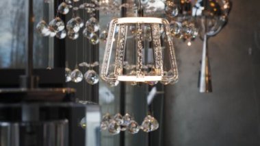 Kristal avizeler mağazada. Yakın plan. Süslü, köpüklü cam gibi parlak bir lamba. İç tasarım için çeşitli aydınlatma araçları.