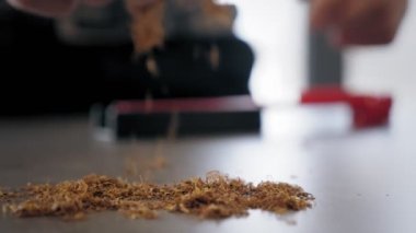 Tütün. Adam tütünü alıp plastik tütün rulo makinesine koyuyor. Modern sigara piposu. - Yakın çekim. Bir adam tütün piposunu hazırlar.