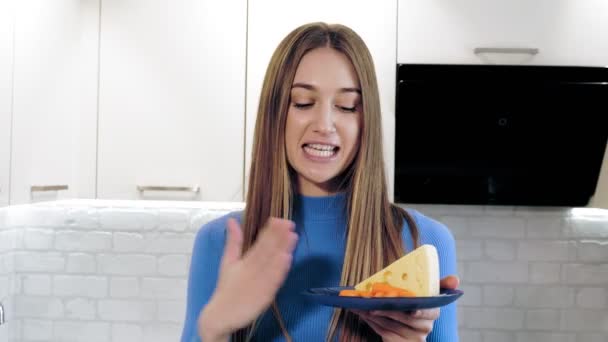 Mode de vie sain. nutritionniste en ligne. belle femme tourne une vidéo sur la nourriture saine dans la cuisine à la maison. elle se tient devant la caméra et parle d'une alimentation saine. Vlogging et médias sociaux. — Video