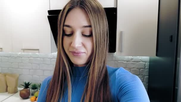 Mode de vie sain. Vlogging et médias sociaux. nutritionniste en ligne. belle femme tourne une vidéo sur la nourriture saine dans la cuisine à la maison. elle se tient devant la caméra et parle d'une alimentation saine. — Video