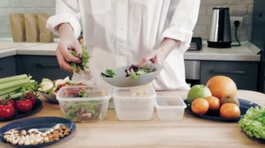 İnternette yemek yapmak. Sağlıklı yemek. Yemek konteynırları. Kadın öğle yemeğini tekrar kullanılabilir yemek kutularında ve beslenme çantalarında paketliyor. Plastik konteynırlarda ev yapımı yemek. Kargo Servisi