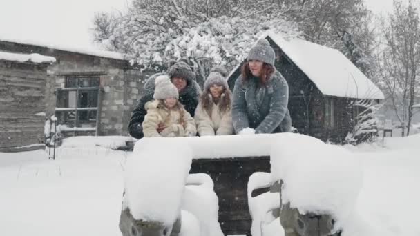 Diversión familiar de invierno. tirando nieve. Feliz, riendo, juguetona familia de 4 es disfrutar de la nieve y las nevadas, divertirse, pasar tiempo juntos en el día de invierno nevado. cámara lenta — Vídeos de Stock