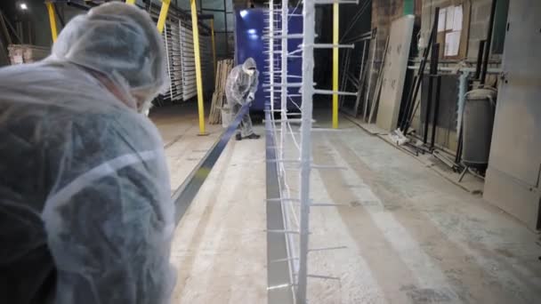 Perde kornişleri. Perde rayları. İşçiler atölyede boyama için özel olarak metal perde kordonları takıyorlar. Perde kordonlarının imalatı. Perdeler için aksesuarlar, pencere dekorasyonu. — Stok video