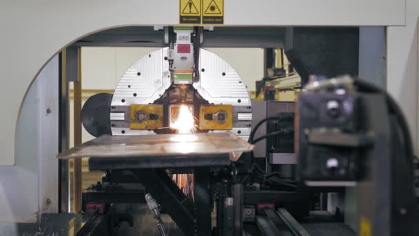 Laserskärmaskin för metallrör. modern maskin med CNC fiber laser skär fyrkantiga metallrör. ljusa brinnande gnistor flyga från laserstråle under skärningsprocessen — Stockvideo