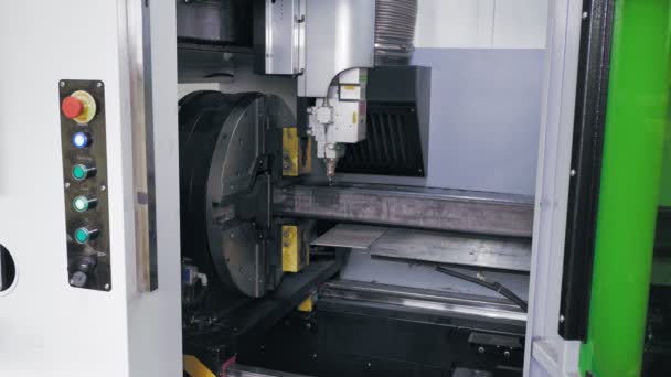 Máquina de corte por láser para tubos metálicos. Vista lateral. máquina moderna con láser de fibra CNC está cortando tubo de metal cuadrado. chispas de combustión brillante vuelan desde el rayo láser durante el proceso de corte — Vídeos de Stock