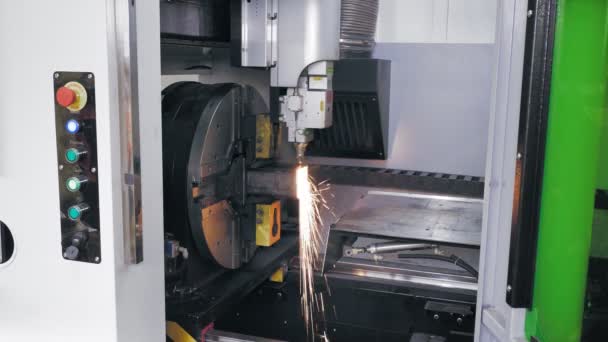 Laserskärmaskin för metallrör. sidovy. modern maskin med CNC fiber laser skär fyrkantiga metallrör. ljusa brinnande gnistor flyga från laserstråle under skärningsprocessen — Stockvideo