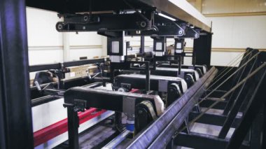 Metal borular için lazer kesme makinesi. Modern, akıllı, CNC endüstriyel ekipmanları fabrikada metal işçiliği için çalışıyor. Kare metal boru hareket ediyor ve dönüyor. Pnömatik kıskaçlar tarafından tutuluyor.