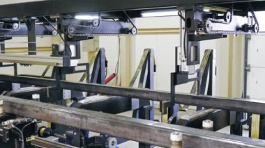 Metal borular için lazer kesme makinesi. Modern, akıllı, endüstriyel ekipmanların çalışma süreci atölyede metal işçiliği için. Kare metal boru hareket ediyor ve dönüyor. Pnömatik kıskaçlar ve klipslerle tutuluyor.