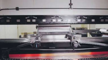 Metal levhanın bükülmesi. Yakın plan. Endüstriyel CNC makinesinde metalin otomatik bükülmesi. Modern, akıllı, endüstriyel ekipmanların çalışma süreci atölyede metal işçiliği için. Modern teknolojiler.