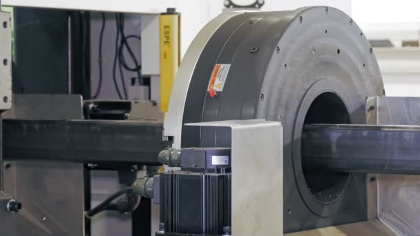 Máquina de corte por láser para tubos metálicos. Primer plano. Vista lateral. tubo de metal cuadrado se mueve y gira, se sostiene por abrazaderas neumáticas, clips de la máquina industrial inteligente en el taller. proceso de trabajo de — Vídeo de stock