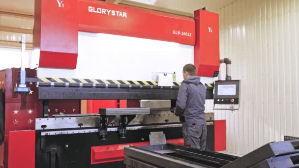 Gięcie blachy stalowej. Operator maszyny do gięcia umieszcza i gięcia przedmiotu z blachy w automatycznej maszynie CNC, w warsztacie. obsługa pras metalowych. Produkcja konstrukcji metalowych — Wideo stockowe