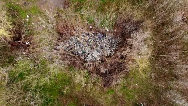 Soptipp i skogen. Ekologiskt problem. Olagligt soptipp mitt i vårskogen. Ovanifrån. En hög med plastpåsar, matavfall, skräp, slängda utomhus. miljöföroreningar — Stockvideo