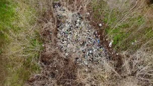 Vuilnisbelt in het bos. Ecologisch probleem. Illegale vuilnisbelt midden in het voorjaarsbos. Bovenaanzicht vanuit de lucht. Een stapel plastic zakken, voedselafval, vuilnis, buiten gegooid. milieuverontreiniging — Stockvideo