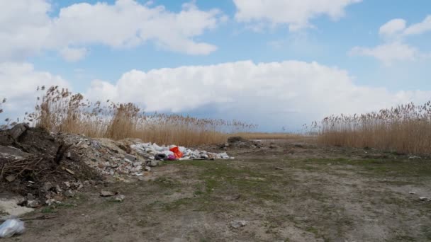 河边的垃圾堆。生态问题。非法建筑垃圾倾倒在河岸上.一堆垃圾，垃圾，扔在外面。垃圾填埋场环境污染. — 图库视频影像