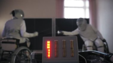 Engelli atlet. Eskrim. Yakın plan. Elektrik tamircisi. Cihaz eskrim kayıtları idman yapan iki tekerlekli sandalyedeki eskrim sporcusunun idman kayıtları.
