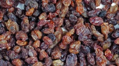 Kuru üzüm. Yakın plan. Rotasyon yemeği. Üzüm arka planı yavaş döner, üst görünüm. Sağlıklı beslenme için kuru meyve, hafif ve koyu kuru üzüm. Yemek geçmişi. Gastronomi konsepti, organik gıda..