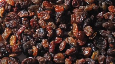 Kuru üzüm. Yakın plan. Rotasyon yemeği. Üzüm arka planı yavaş döner, üst görünüm. Sağlıklı beslenme için kuru meyve, hafif ve koyu kuru üzüm. Yemek geçmişi. Gastronomi konsepti, organik gıda..