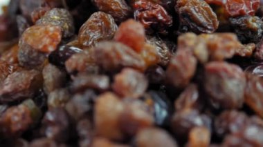 Kuru üzüm. Yakın plan. Rotasyon yemeği. Üzüm arka planı yavaş döner, üst görünüm. Sağlıklı beslenme için kuru meyve, hafif ve koyu kuru üzüm. Yemek geçmişi. Gastronomi konsepti, organik gıda..