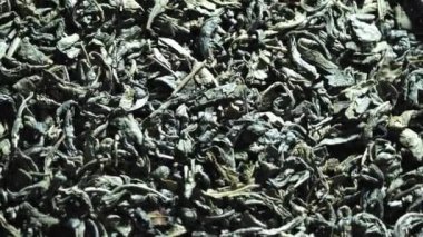 Kuru yeşil çay. Yakın plan. Rotasyon yemeği. Pişmemiş ve kurutulmuş çay. kıvrılmış ve sarılmış çay yaprakları. Makro.