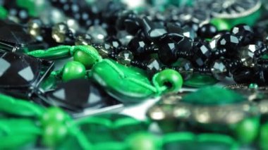 Mücevher, boncuk. Yakın plan. Döndürme. Parlak, pırıl pırıl mücevherler ve pırıl pırıl mücevherler. Makro. Bir sürü farklı renkte boncuk. çeşitli mücevherler, taş ürünleri, yeşil malakit boncuklar..